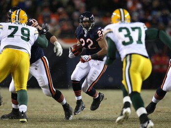 CHICAGO - DECEMBER 22:  Matt Forte #22 of the Chicago Bears runs for yardage as Aaron Rouse #37 of the Green Bay Packers closes in on December 22, 2008 at Soldier Field in Chicago, Illinois. (Photo by Jonathan Daniel/Getty Images)