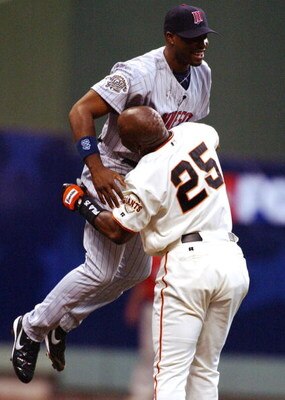 MILWAUKEE, WI - JULY 9:  Barry Bonds #25 of the National League picks up Torii Hunter #48 of the American League after Hunter robbed Bonds of a homerun at the wall for the first out in the first inning during the MLB All- Star Game on July 9, 2002 at Mill