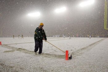 GREEN BAY, WI - JANUARY 12:  A field crew member sweeps the snow in the endzone during the game between the Green Bay Packers and the Seattle Seahawks during the NFC divisional playoff game on January 12, 2008 at Lambeau Field in Green Bay, Wisconsin.  (P