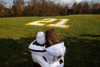 ASHBURN, VA - NOVEMBER 27:  Washington Redskins fans Natalie Ragnati (L) and Amy Goldsmith (R) embrace in front of Sean Taylor's number 21 painted onto a field at Redskins Park November 27, 2007 in Ashburn, Virginia. Taylor died earlier this morning from 