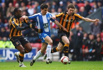 WIGAN, UNITED KINGDOM - MARCH 22:  Paul Scharner (C) of Wigan breaks past Samuel Ricketts (R) and Kamil Zayatte of Hull during the Barclays Premier League match between Wigan Athletic and Hull City at The JJB Stadium on March 22, 2009 in Wigan, England.  