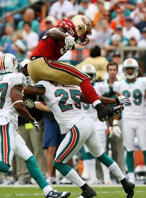 MIAMI - DECEMBER 14:  Tight end Vernon Davis #85 of the San Francisco 49ers tries to hurdle cornerback Will Allen #25 of the Miami Dolphins at Dolphin Stadium on December 14, 2008 in Miami, Florida.  (Photo by Doug Benc/Getty Images)