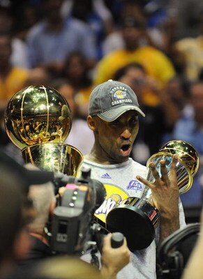 ORLANDO, FL - JUNE 14:  Kobe Bryant #24 of the Los Angeles Lakers holds the Bill Russell MVP trophy and the Larry O'Brien trophy after defeating the Orlando Magic in Game Five of the 2009 NBA Finals on June 14, 2009 at Amway Arena in Orlando, Florida. The