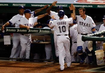 ARLINGTON, TX - JULY 27:  Third baseman Michael Young #10 of the Texas Rangers celebrates a run in the dugout on July 27, 2009 at Rangers Ballpark in Arlington, Texas.  (Photo by Ronald Martinez/Getty Images)