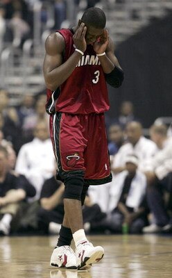 WASHINGTON - MAY 14:  Dwyane Wade #3 of the Miami Heat tries to collect himself after colliding with Larry Hughes of the Washington Wizards during first half action of Game four of the Semifinals of the Eastern Conference 2005 NBA Playoffs on May 14, 2005
