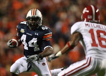 AUBURN, AL - NOVEMBER 24:  Running back Ben Tate #44 of the Auburn Tigers looks to avoid a tackle by defensive back Lionel Mitchell #16 of the Alabama Crimson Tide at Jordan-Hare Stadium on November 24, 2007 in Auburn, Alabama.  (Photo by Doug Benc/Getty 