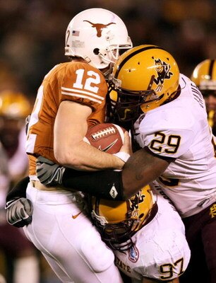 SAN DIEGO - DECEMBER 27:  Quarterback Colt McCoy #12 of the Texas Longhorns is sacked for a loss by Robert James #29 and Luis Vasquez #97 of the Arizona State Sun Devils during the 2nd half of the Pacific Life Holiday Bowl on December 27, 2007 at Qualcomm