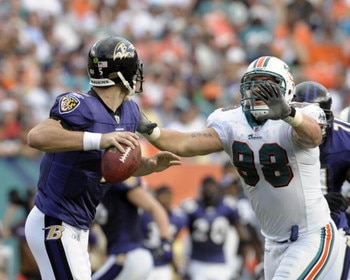 MIAMI, FL - JANUARY 4:  Linebacker Matt Roth #98 of the Miami Dolphins rushes quarterback Joe Flacco #5 of the Baltimore Ravens in an NFL Wildcard Playoff Game at Dolphins Stadium on January 4, 2009 in Miami, Florida.  (Photo by Al Messerschmidt/Getty Ima