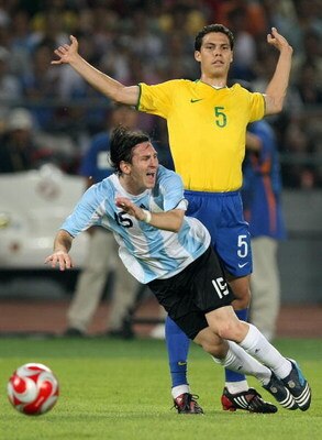 BEIJING - AUGUST 19:  Lionel Messi of Argentina goes down after a challenge from Hernanes of Brazil during the men's football semifinal match at Workers' Stadium on Day 11 of the Beijing 2008 Olympic Games on August 19, 2008 in Beijing, China.  (Photo by 