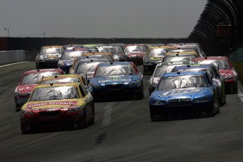 WATKINS GLEN, NY - AUGUST 10:  Marcos Ambrose, driver of the #47 Little Debbie/Kingsford/Clorox Toyota, leads a group of cars during the NASCAR Sprint Cup Series Heluva Good! Sour Cream Dips at Watkins Glen International on August 10, 2009 in Watkins Glen