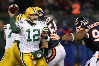 CHICAGO - DECEMBER 22: Aaron Rodgers #12 of the Green Bay Packers looks for a receiver under pressure from Marcus Harrison #94 of the Chicago Bears on December 22, 2008 at Soldier Field in Chicago, Illinois. The Bears defeated the Packers 20-17 in overtim