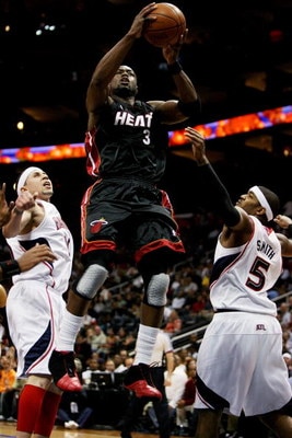 ATLANTA - APRIL 22:  Dwyane Wade #3 of the Miami Heat drives between Mike Bibby #10 and Josh Smith #5 of the Atlanta Hawks during Game Two of the Eastern Conference Quarterfinals at Philips Arena on April 22, 2009 in Atlanta, Georgia. NOTE TO USER: User e