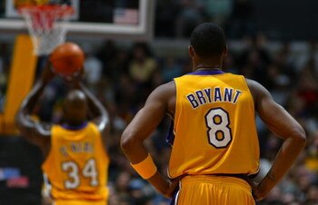 LOS ANGELES - FEBRUARY 26:  Kobe Bryant #8 of the Los Angeles Lakers watches teammate Shaquille O'Neal #34 shoot a free throw against the Sacramento Kings during the game at Staples Center on February 26, 2004 in Los Angeles, California.  The Kings won 10
