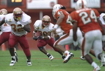 12 Oct 1996: Running back Warrick Dunn #28 of the Florida State Seminoles keeps his eyes focused upfield at pursuing defenders from the Miami Hurricanes as he makes a cut through a hole in the offensive line during a carry in the Seminoles 34-16 victory o