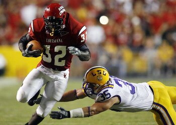BATON ROUGE, LA - SEPTEMBER 02:  Tyrell Fenroy #32 of the University of Louisiana Lafayette avoids a tackle by Luke Sanders #35 of Louisiana State University on September 2, 2006 at Tiger Stadium in Baton Rouge, Louisiana.  LSU defeated ULL 45-3.  (Photo 
