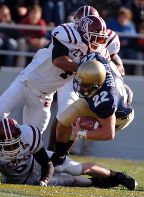 ANNAPOLIS, MD - NOVEMBER 19:  In this handout from the U.S. Navy, U.S. Naval Academy Midshipman full back Adam Ballard #22 is tackled by Temple Owls defender Justin Johnson #4 during the 1st quarter of play on November 19, 2005 at Navy Memorial Stadium in