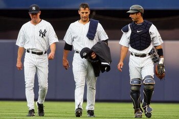 NEW YORK - JULY 01:  Pitcher Andy Pettitte #46 (C) of the New York Yankees walks in from the bullpen to start the game against the Seattle Mariners with teammate Jorge Posada #20 and pitching coach Dave Eiland on July 1, 2009 at Yankee Stadium in the Bron