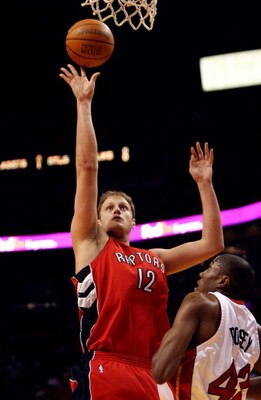 MIAMI - APRIL 03:  Rasho Nesterovic #12 of the Toronto Raptors scores over James Posey #42 of the Miami Heat at American Airlines Arena on April 3,  2007 in Miami, Florida.  NOTE TO USER: User expressly acknowledges and agrees that, by downloading and or 