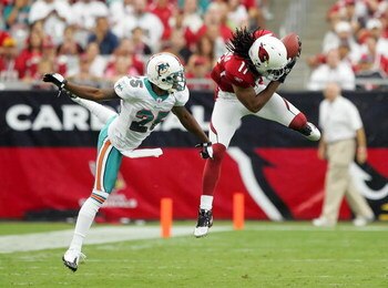 GLENDALE, AZ - SEPTEMBER 14:  Larry Fitzgerald #11 of the Arizona Cardinals completes a pass against Will Allen #25 of the Miami Dolphins at University of Phoenix Stadium on September 14, 2008 in Glendale, Arizona.  (Photo by Lisa Blumenfeld/Getty Images)