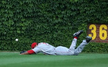 CHICAGO - JULY 26: Chris Dickerson #21 of the Cincinnati Reds hits the ground trying to make a catch in the 8th inning against the Chicago Cubs on July 26, 2009 at Wrigley Field in Chicago, Illinois. The Cubs defeated the Reds 5-2.  (Photo by Jonathan Dan