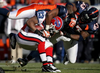 DENVER - DECEMBER 21: Running back Marshawn Lynch #23 of the Buffalo Bills is tackled by Jamie Winborn #51 and Dewayne Robertson #63 of the Denver Broncos during NFL action at Invesco Field at Mile High on December 21, 2008 in Denver, Colorado. The Bills