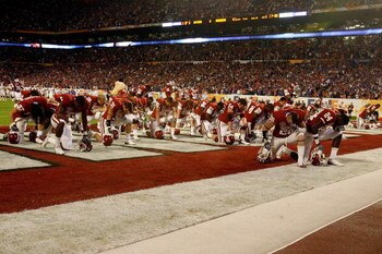 MIAMI - JANUARY 08:  Players from the Oklahoma Sooners kneel and pray in the endzone prior to playing against the Florida Gators during the FedEx BCS National Championship game at Dolphin Stadium on January 8, 2009 in Miami, Florida.  (Photo by Doug Benc/