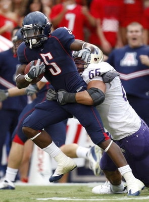 TUCSON, AZ - OCTOBER 04:  Nic Grigsby #5 of the Arizona Wildcats tries to escape the tackle of Daniel Te'o-Nesheim #66 of the Washington Huskies during a first quarter run on October 4, 2008 at Arizona Stadium in Tucson, Arizona.  (Photo by Gregory Shamus