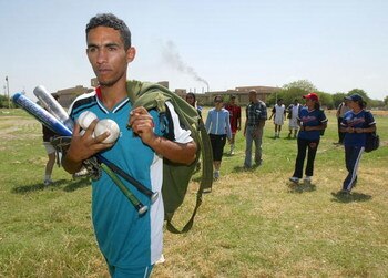 BAGHDAD, IRAQ - MAY 10:  A Baghdad baseball team player carries balls and bats as softball and baseball players leave the field after practice May 10, 2005 in Baghdad, Iraq. The Iraqi national baseball and softball federation was established after the fal
