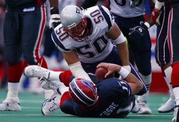 ORCHARD PARK, NY - November 3:  Mike Vrabel #50 of the New England Patriots kneels over Drew Bledsoe of the Buffalo Bills after Vrabel sacked Bledsoe on November 3, 2002 at Ralph Wilson Stadium in Orchard Park, New York.  The Patriots won 38-7.  (Photo by