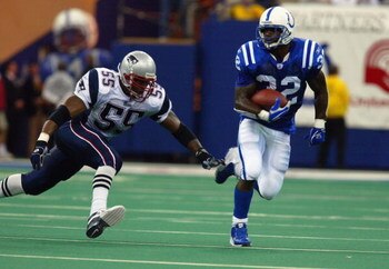 INDIANAPOLIS, IN - NOVEMBER 30:  Running back Edgerrin James #32 of the Indianapolis Colts evades defensive end Willie McGinest #55 of the New England Patriots during the game at the RCA Dome on November 30, 2003 in Indianapolis, Indiana. The Patriots def
