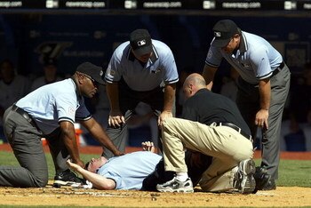 TORONTO - AUGUST 6:  Home plate umpire Marty Foster lies injured, suffering a contusion over his right knee after being hit by a broken bat in the second inning of the Toronto Blue Jays game against New York Yankees at Rogers Centre on August 6, 2005 in T
