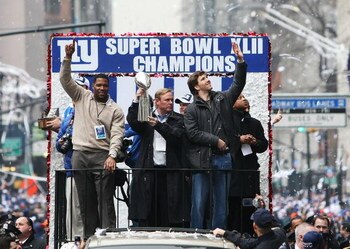 NEW YORK - FEBRUARY 05:  (L-R) Michael Strahan, Owner John Mara and Eli Manning of the New York Giants ride in a float along Broadway, also known as 'The Canyon of Heroes' during Super Bowl XLII victory parade in New York City.  (Photo by Al Bello/Getty I