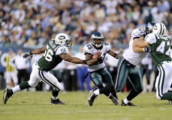PHILADELPHIA - AUGUST 28: Lorenzo Booker #25 of the Philadelphia Eagles rushes as Vernon Gholston #56 of the New York Jets tries to make a tackle during a preseason game at Lincoln Financial Field on August 28, 2008 in Philadelphia, Pennsylvania. (Photo b