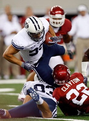 ARLINGTON, TX - SEPTEMBER 05:  Running back Bryan Kariya #33 of the Brigham Young Cougars is tackled by Keenan Clayton #22 of the Oklahoma Sooners at Cowboys Stadium on September 5, 2009 in Arlington, Texas.  (Photo by Ronald Martinez/Getty Images)