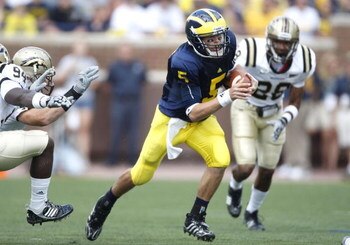 ANN ARBOR, MI - SEPTEMBER 05:  Tate Forcier #5 of the Michigan Wolverines looks for running room in front of Keith Dixson #28 of the Western Michigan Broncos on September 5, 2009 at Michigan Stadium in Ann Arbor, Michigan.  (Photo by Gregory Shamus/Getty 