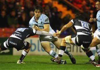 STOCKPORT, ENGLAND - SEPTEMBER 04:  Matt Smith (C) of Leicester is tackled during the Guinness Premiership match between Sale Sharks and Leicester Tigers at Edgeley Park on September 4, 2009 in Stockport, England.  (Photo by David Rogers/Getty Images)