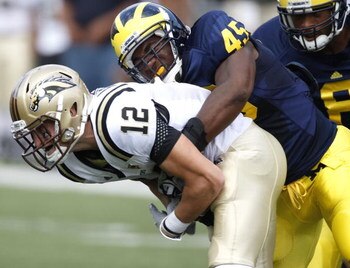 ANN ARBOR, MI - SEPTEMBER 05:  Obi Ezeh #45 of the Michigan Wolverines sacks Tim Hiller #3 of the Western Michigan Broncos on September 5, 2009 at Michigan Stadium in Ann Arbor, Michigan. Michigan won the game 31-7. (Photo by Gregory Shamus/Getty Images)