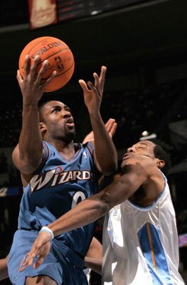DENVER - DECEMBER 18:  Gilbert Arenas #0 of the Washington Wizards puts up a shot against the defense of Marcus Camby #23 of the Denver Nuggets during NBA action on December 18, 2006 at the Pepsi Center in Denver, Colorado. NOTE TO USER: User expressly ac