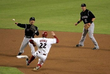 PHOENIX - OCTOBER 11:  Infielder Kazuo Matsui #7 of the Colorado Rockies throws over Eric Byrnes #22 of the Arizona Diamondbacks to compete a double play during the sixth inning of Game One of the National League Championship Series at Chase Field on Octo