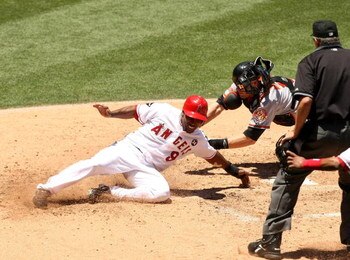 ANAHEIM, CA - JULY 5:   Chone Figgins #9 of the Los Angeles Angels of Anaheim slides safely into home ahead of the tag o catcher Matt Wieters #15 of fthe Baltimore Orioles in the third inning on July 5, 2009 at Angel Stadium in Anaheim, California.    (Ph