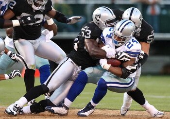 OAKLAND, CA - AUGUST 13:  Running back Marion Barber #24 of the Dallas Cowboys is tackled by Thomas Howard #53 and Ricky Brown #57 of the Oakland Raiders in the first quarter during the preseason game at Oakland-Alameda County Coliseum on August 13, 2009 