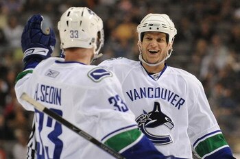 DALLAS - MARCH 24:  Henrik Sedin #33 of the Vancouver Canucks celebrates his goal with Kevin Bieksa #3 during play against the Dallas Stars at the American Airlines Center on March 24 , 2009 in Dallas, Texas.  (Photo by Ronald Martinez/Getty Images)