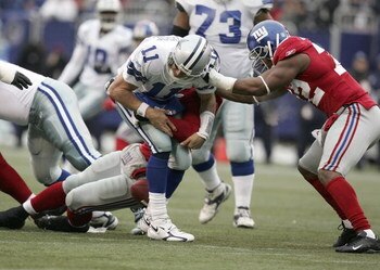EAST RUTHERFORD, NJ - DECEMBER 04:  Justin Tuck #91 of the New York Giants forces a fumble as he and teammate Osi Umenyiora #72 sack Drew Bledsoe #11 of the Dallas Cowboys during their game at Giants Stadium on December 4, 2005 in East Rutherford, New Jer
