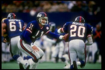 20 Dec 1986:  Quarterback Phil Simms of the New York Giants (left) hands off the ball to teammate running back Joe Morris during a game against the Green Bay Packers at Giants Stadium in East Rutherford, New Jersey.  The Giants won the game, 55-24. Mandat