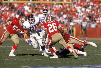 SAN FRANCISCO - JANUARY 20:  Tight end Mark Bavaro #89 of the New York Giants runs with the ball against linebacker Keith DeLong #59 and cornerback Darryl Pollard #26 of the San Francisco 49ers in the 1990 NFC Championship game at Candlestick Park on Janu