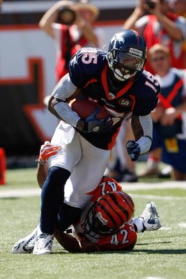 CINCINNATI, OH - SEPTEMBER 13:  Wide receiver Brandon Marshall #15 of the Denver Broncos runs with the football as he is tackled by Chris Crocker #42 of the Cincinnati Bengals at Paul Brown Stadium on September 13, 2009 in Cincinnati, Ohio. The Broncos de