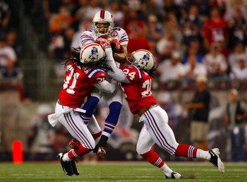 FOXBORO, MA - SEPTEMBER 14:  Wide receiver Josh Reed #82 of the Buffalo Bills complete a pass between Brandon Meriweather #31 and Jonathan Wilhite #24 of the New England Patriots during the first quarter of the game on September 14, 2009 at Gillette Stadi
