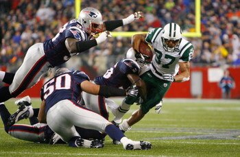FOXBORO, MA - NOVEMBER 13:  Laveranues Coles #87 of the New York Jets gains yardage against the defense of Jarvis Green #97 and Mike Vrabel #50 of the New England Patriots at Gillette Stadium on November 13, 2008 in Foxboro, Massachusetts. (Photo by Jim R