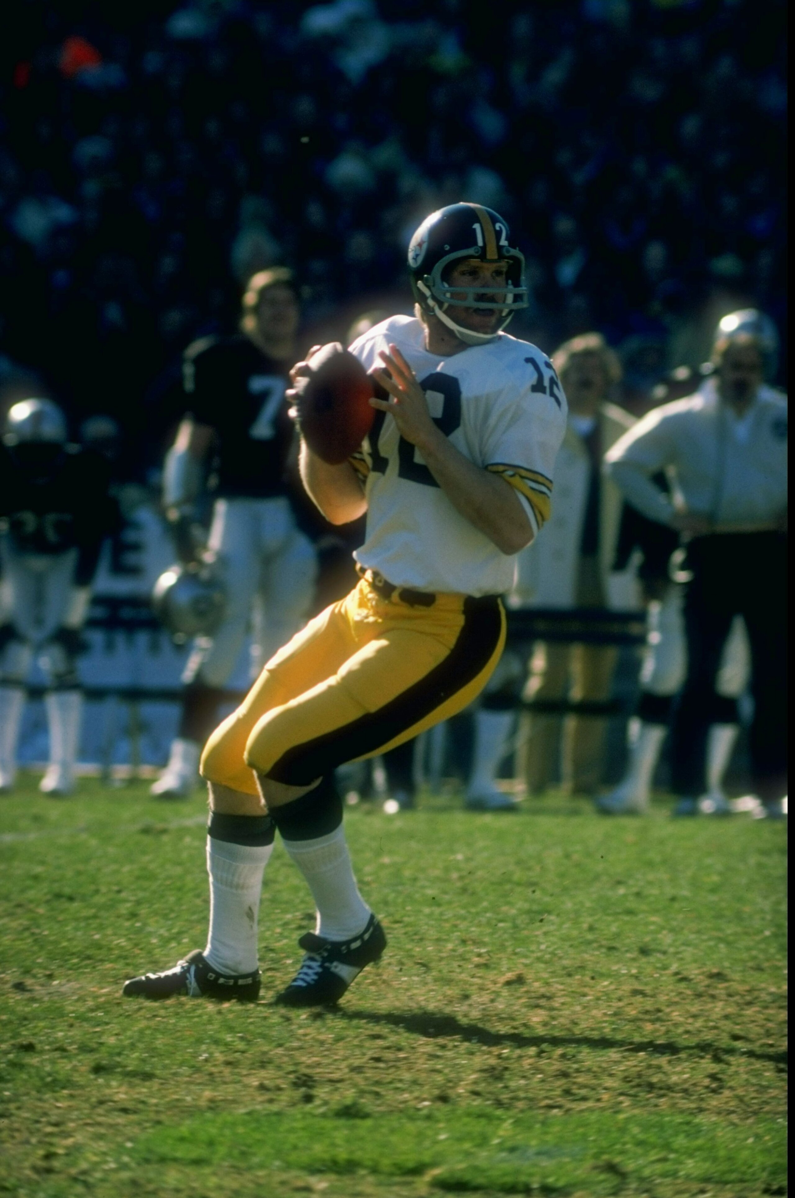 1977:  Quarterback Terry Bradshaw #12 of the Pittsburgh Steelers drops back to pass during a game against the Oakland Raiders at the Oakland Coliseum in Oakland, California. The Raiders defeated the Steelers 16-7. Mandatory Credit: Allsport  /Allsport