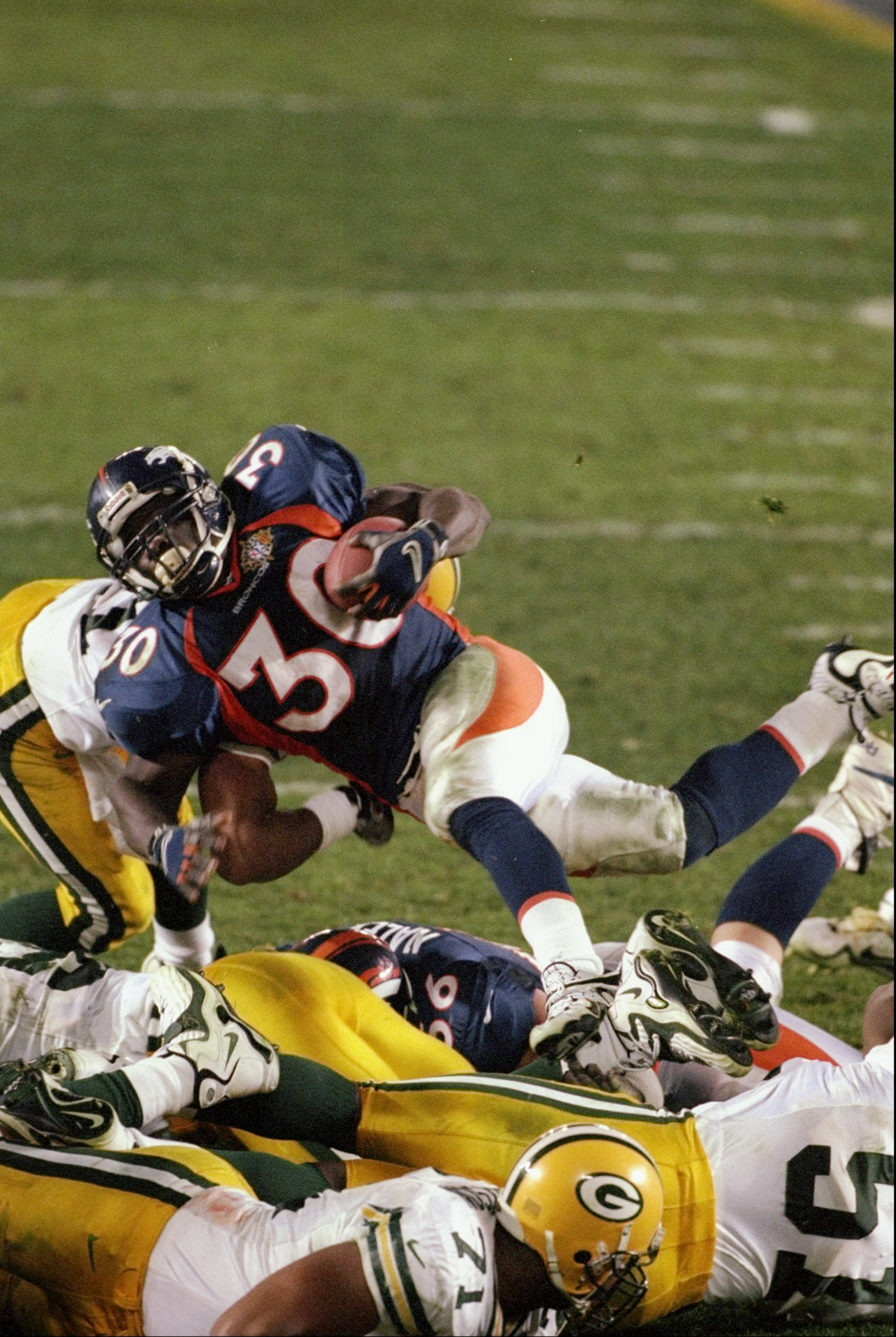 25 Jan 1998: Running back Terrell Davis #30 of the Denver Broncos carries the football over a pile of Green Bay Packers during Super Bowl XXXII at Qualcomm Stadium in San Diego, California. The Denver Broncos defeated the Green Bay Packers 31-24.